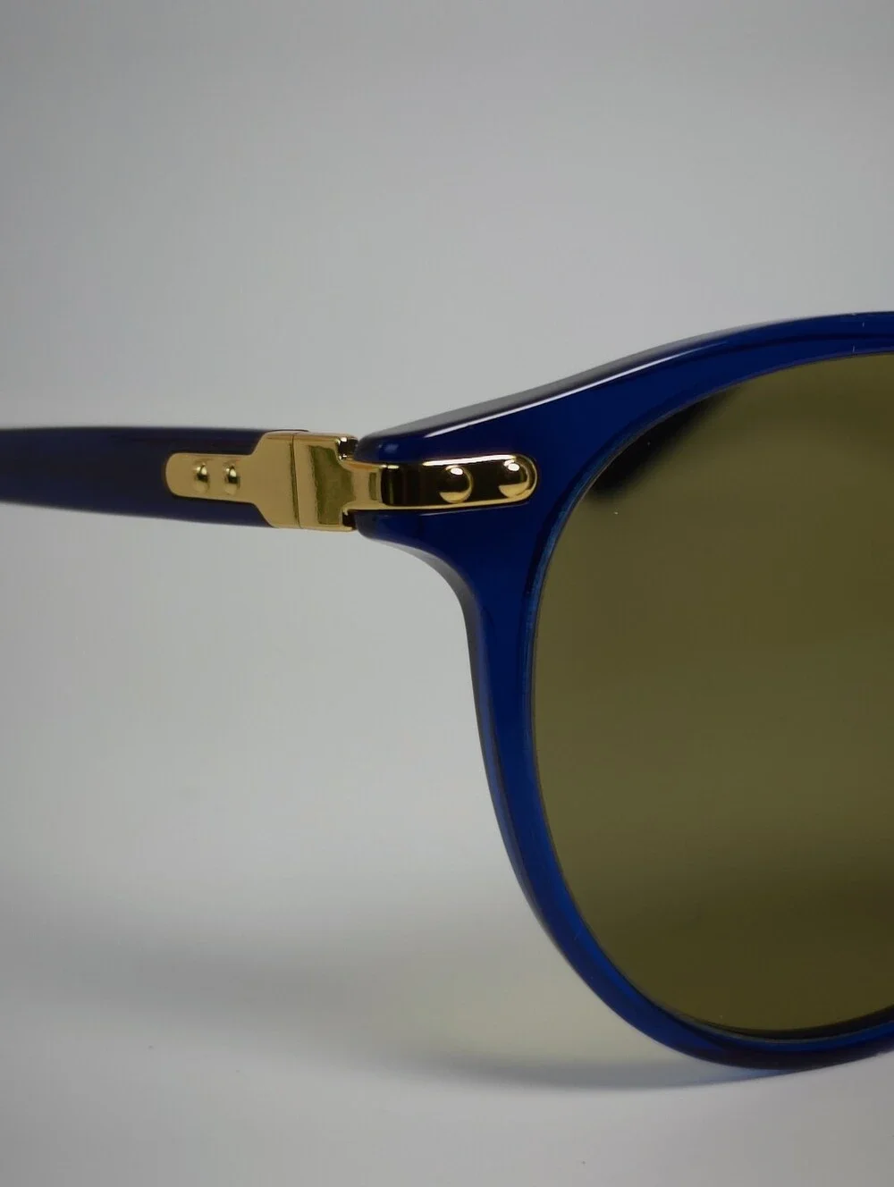 Dotti. Round Navy Translucent frame. Gold Hinge Extends to frame front.